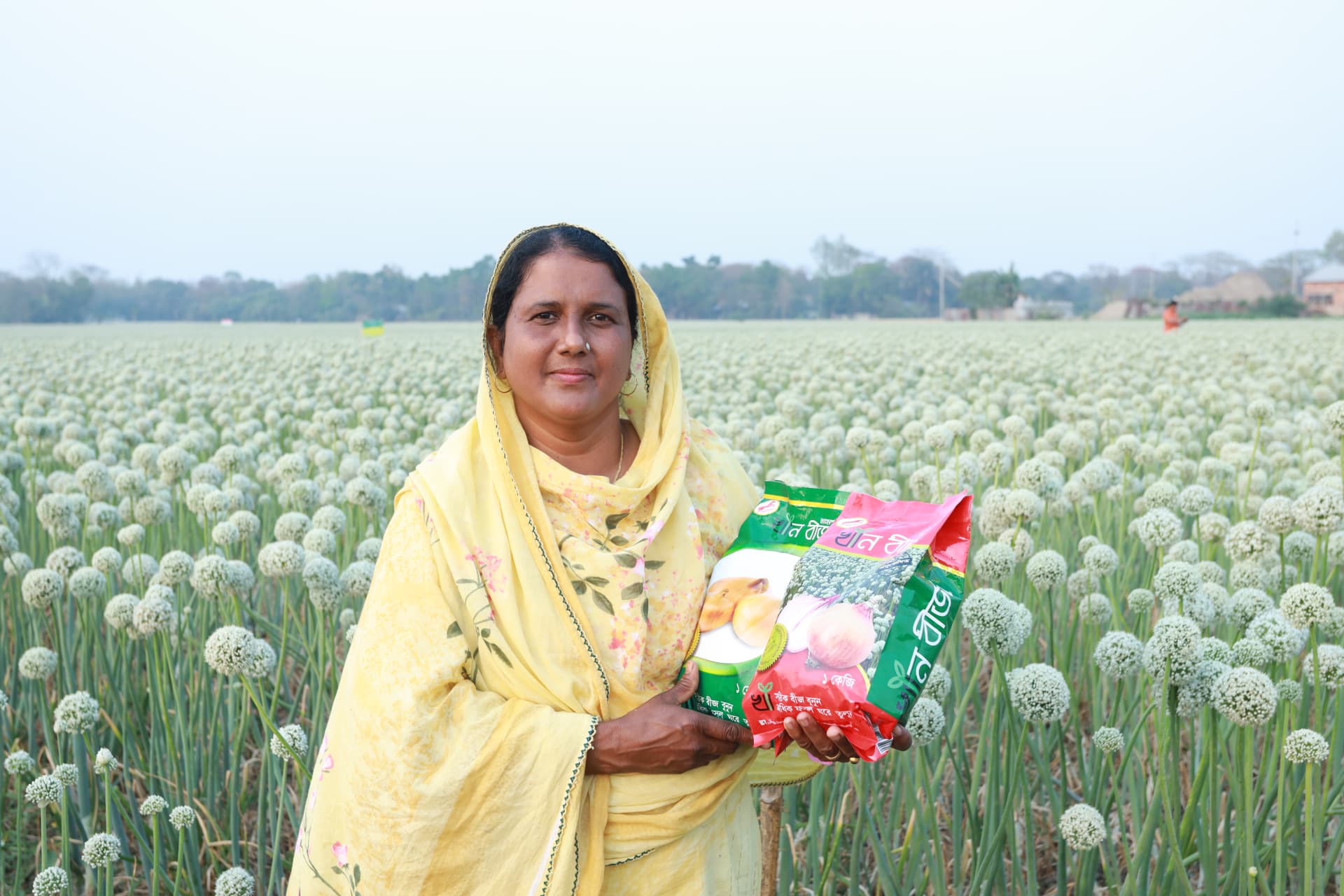 Woman holding Khan Seed onion seed packets in the field